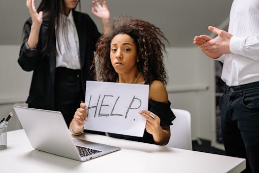 person working on a laptop with a pained expression