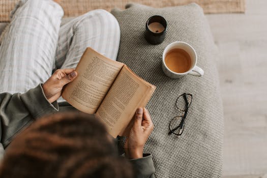 image of a person reading a book with a cup of tea